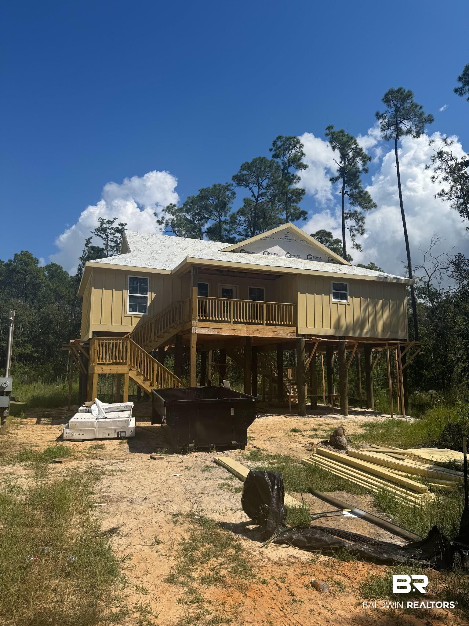 Image 1: Elevated residence under construction featuring wood siding