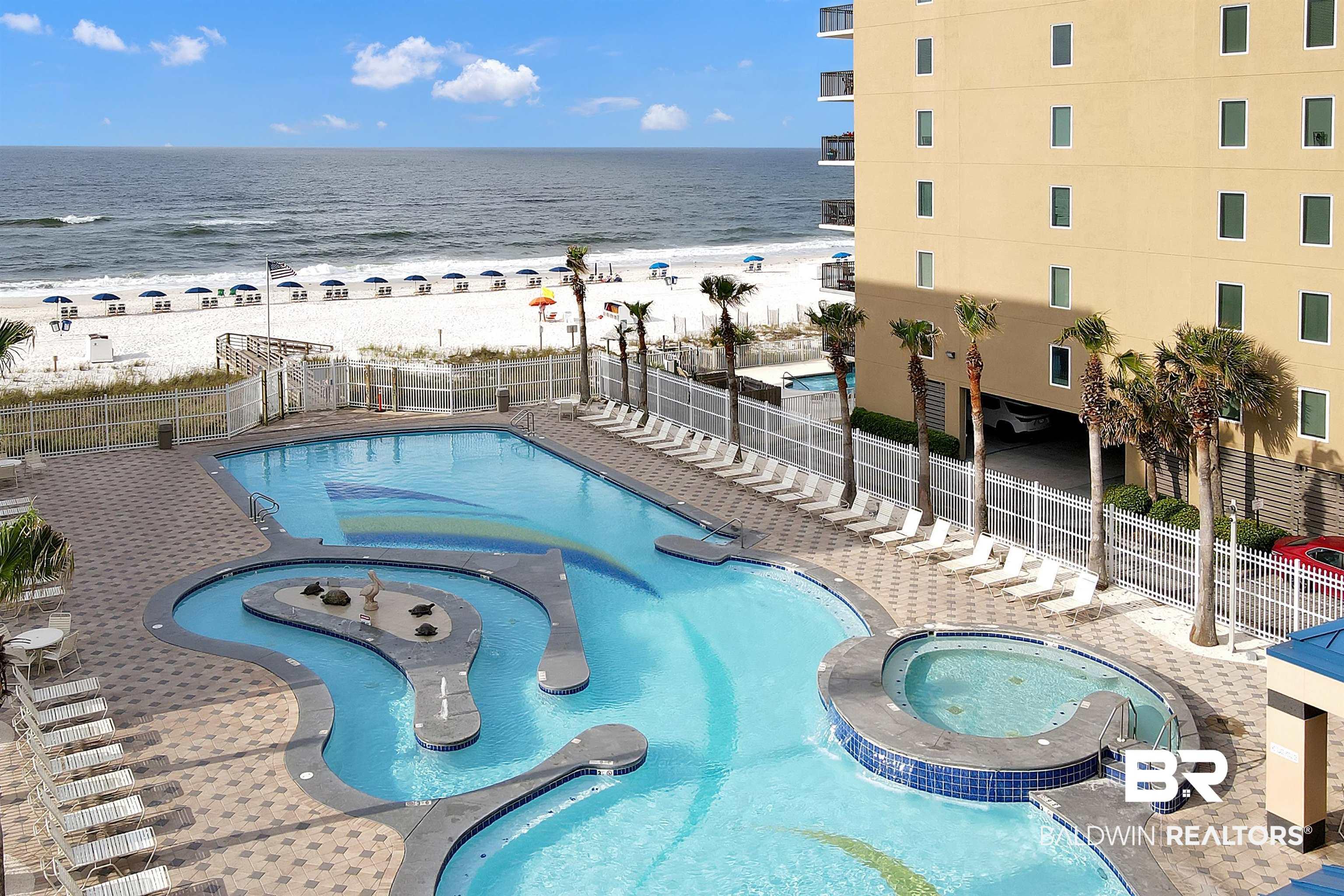 Image 4: Expansive outdoor pool deck featuring a large swimming pool with an integrated lazy river and a separate hot tub