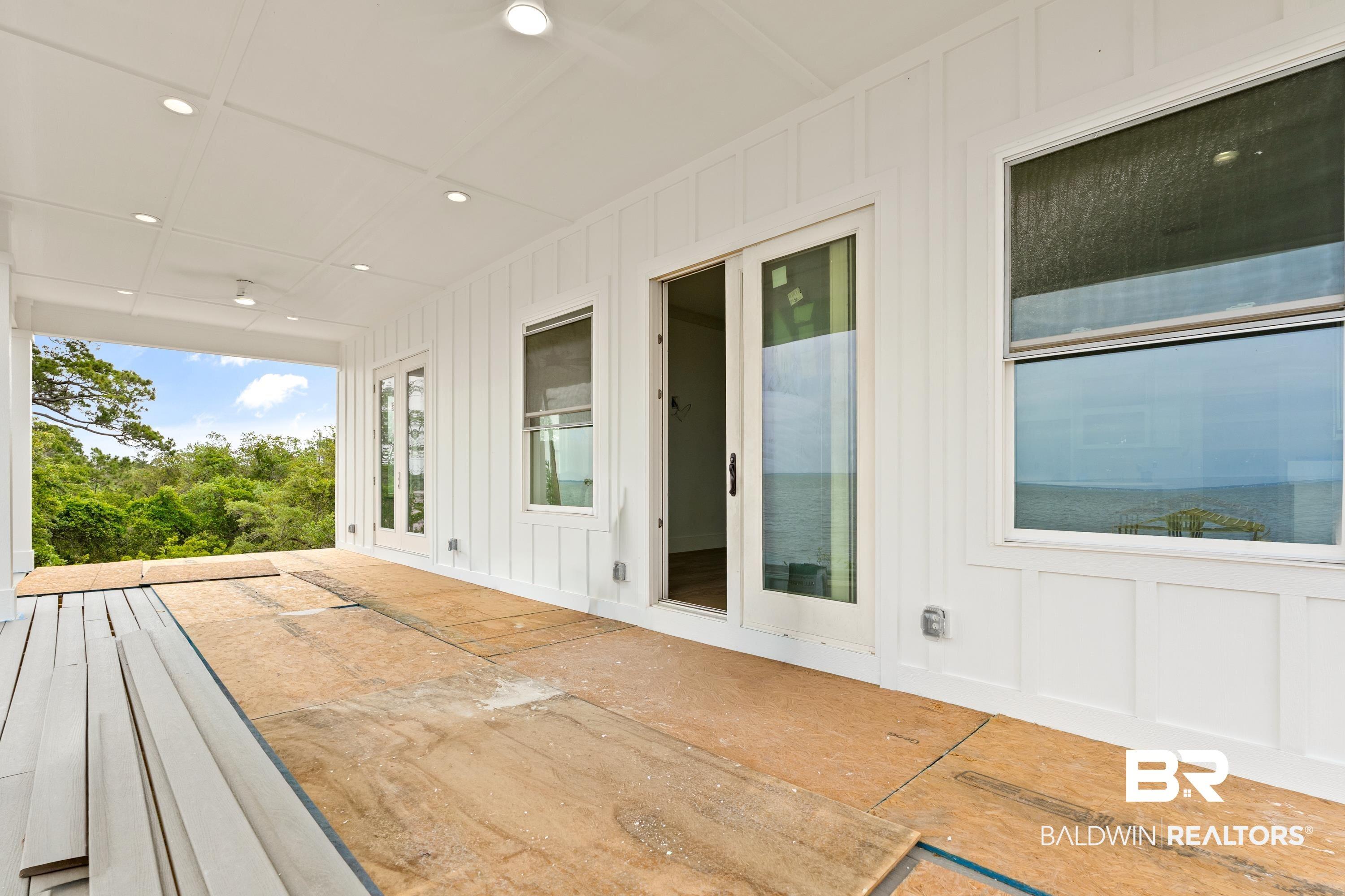 Image 4: Covered outdoor living space featuring white board and batten siding