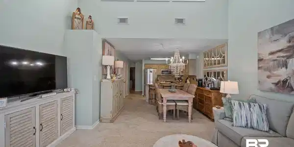 Image 4: Living room with a chandelier, light marble finish floors, plenty of natural light, and a high ceiling