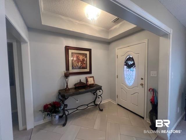Image 3: Foyer featuring a decorative glass-paneled entry door, tray ceiling with recessed lighting, light-toned tile flooring laid in a herringbone pattern, and a wide cased opening