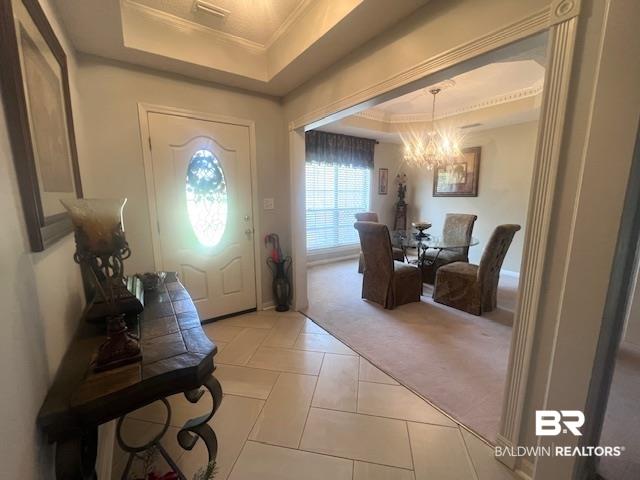 Image 4: Foyer with light tile flooring and tray ceiling, opening to a formal dining area with a chandelier, crown molding, and a window with blinds