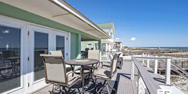 Image 3: Deck featuring outdoor dining area and a water view