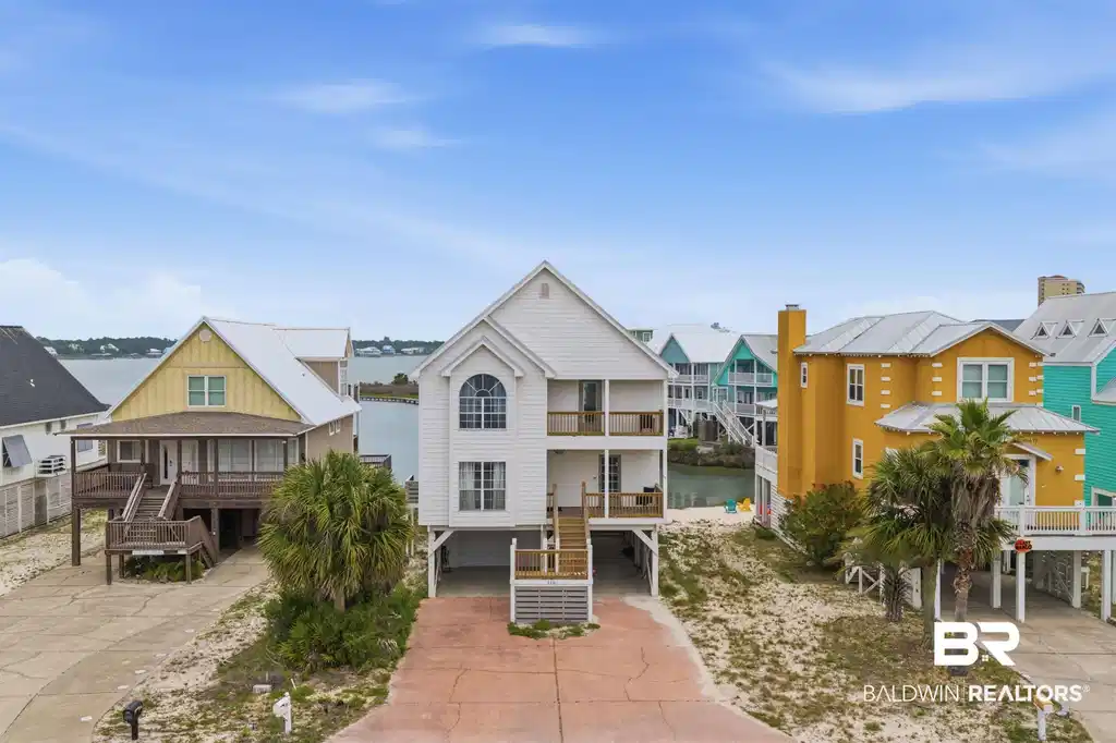 Image 1: Two-story coastal residence featuring multiple balconies and a prominent arched window