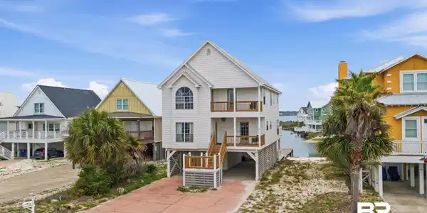 Image 2: Three-story coastal residence featuring a white exterior with multiple balconies