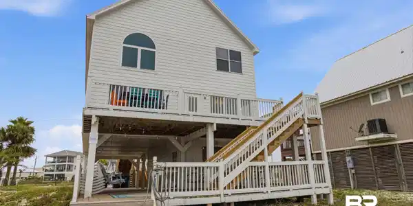 Image 3: Elevated coastal residence featuring white siding and a multi-level deck