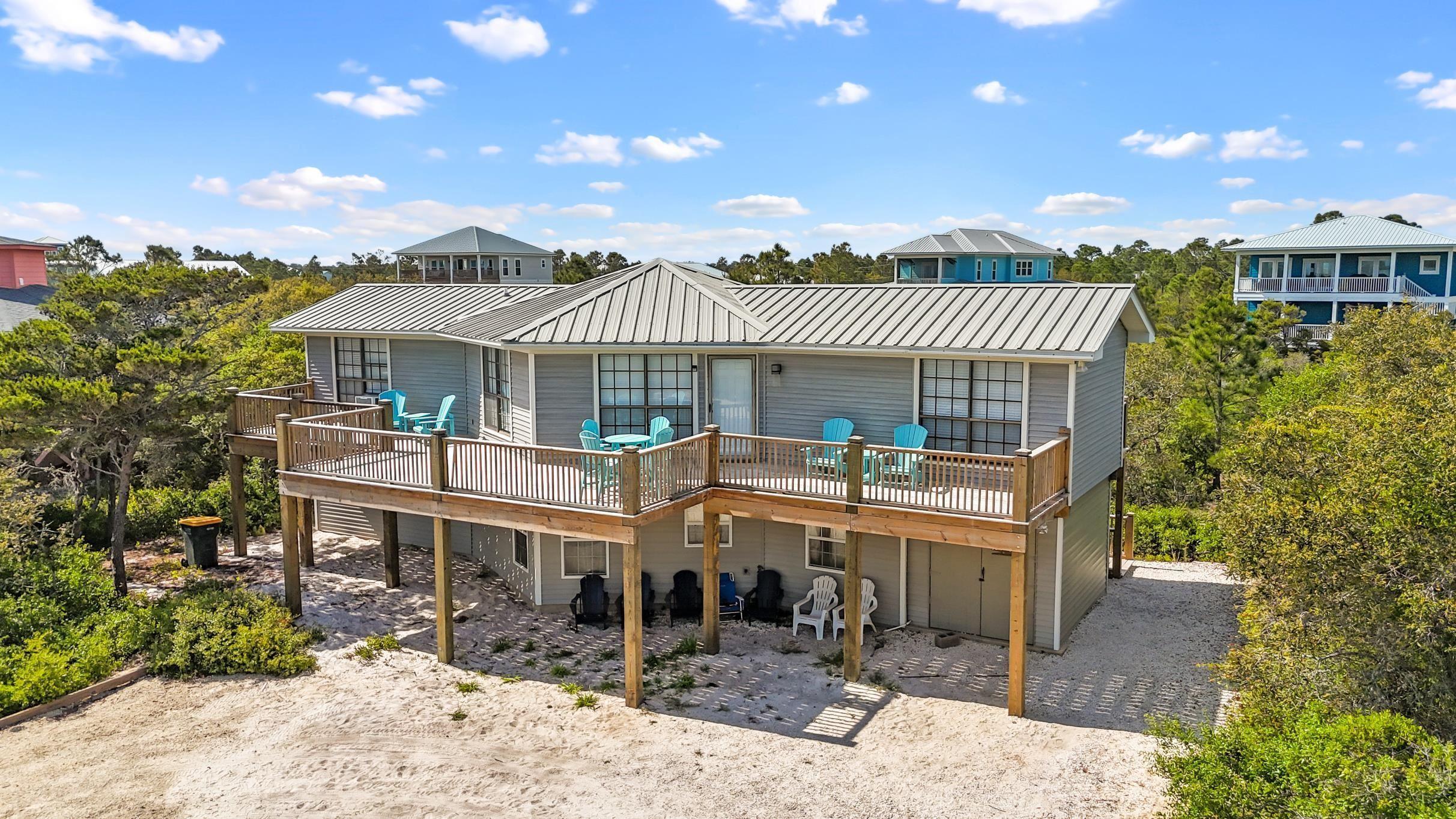 Image 2: Back of house featuring metal roof and a wooden deck