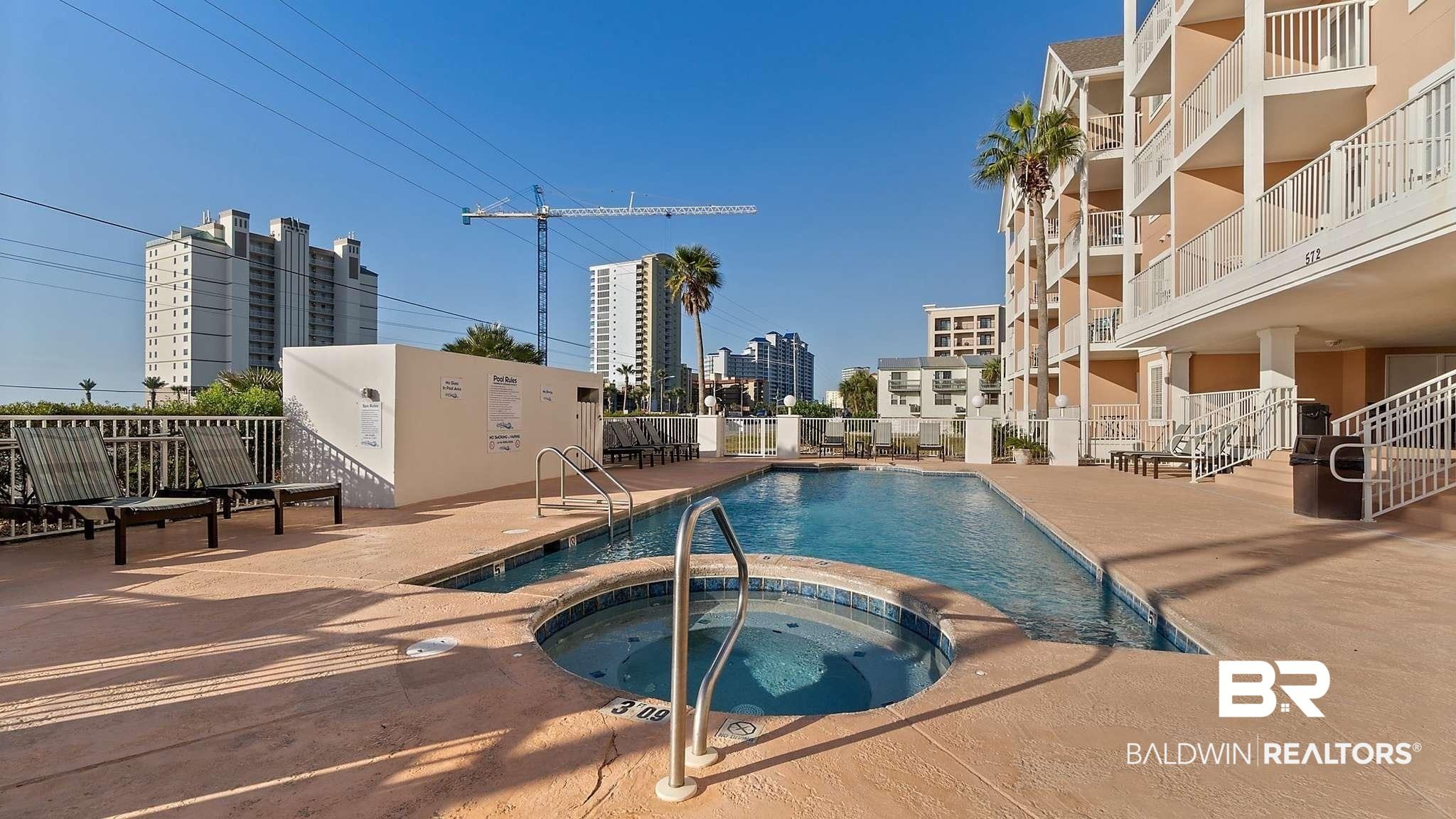Image 2: Community pool with a hot tub and a patio area