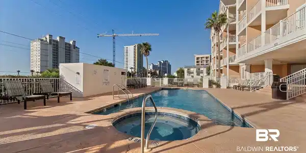 Image 2: Community pool with a hot tub and a patio area