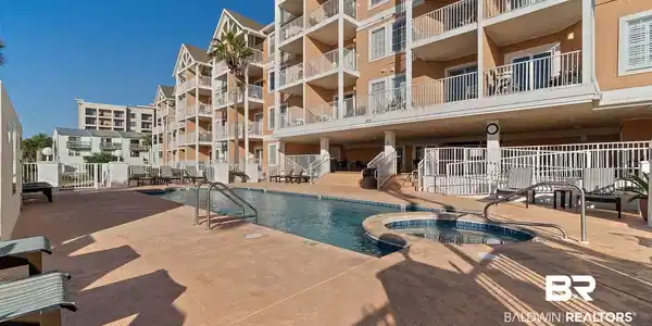 Image 3: Community pool featuring a hot tub and a patio