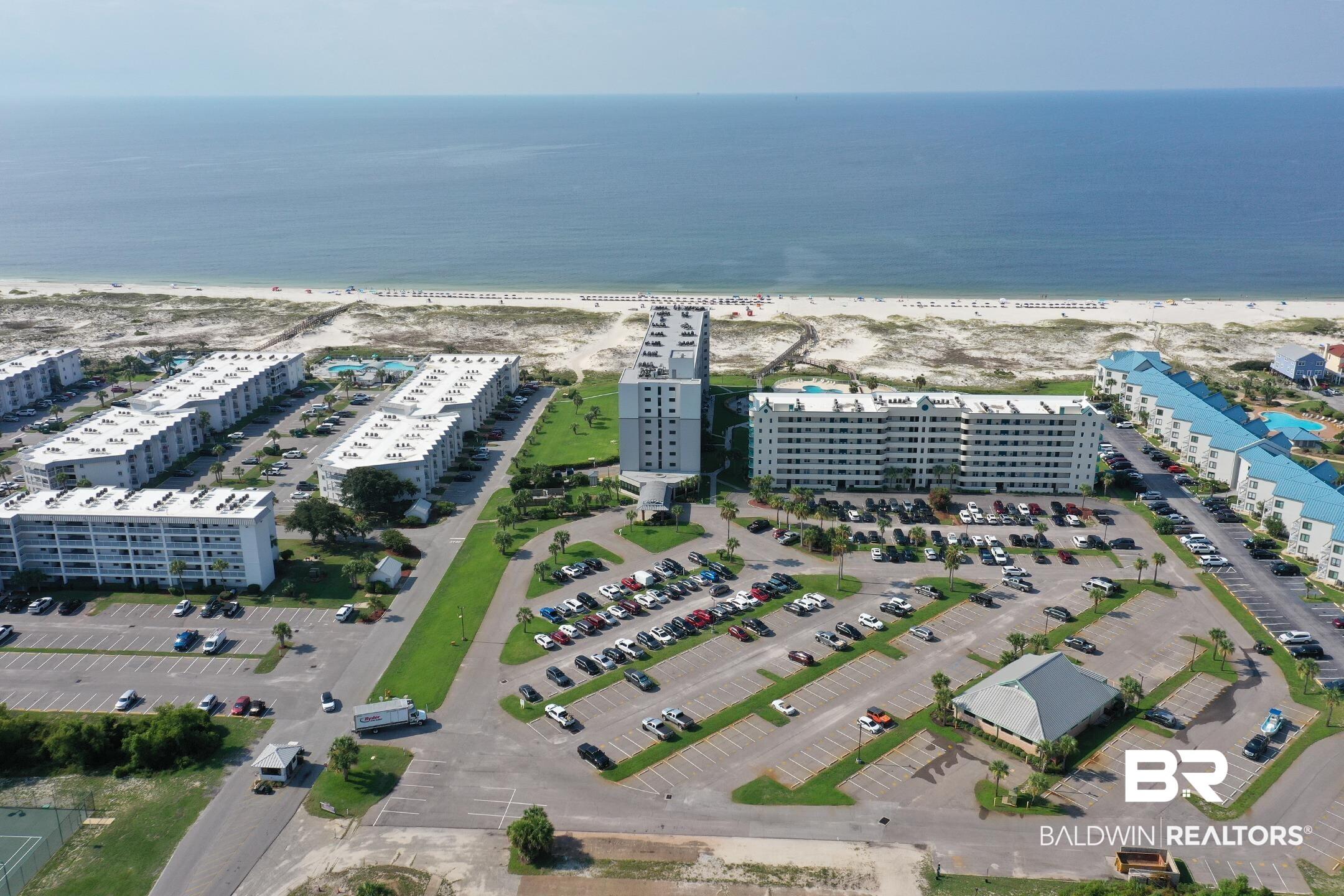 Image 1: Bird's eye view of apartment complex and expansive beach