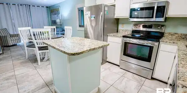 Image 2: Kitchen featuring stainless steel appliances, white cabinets, a kitchen island, light stone counters, and ceiling fan
