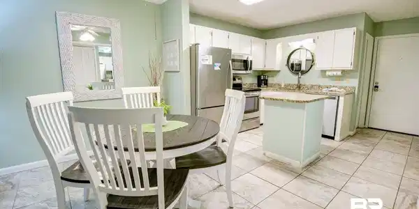 Image 4: Kitchen with white cabinetry, a kitchen island, stainless steel appliances, light stone countertops, and a ceiling fan
