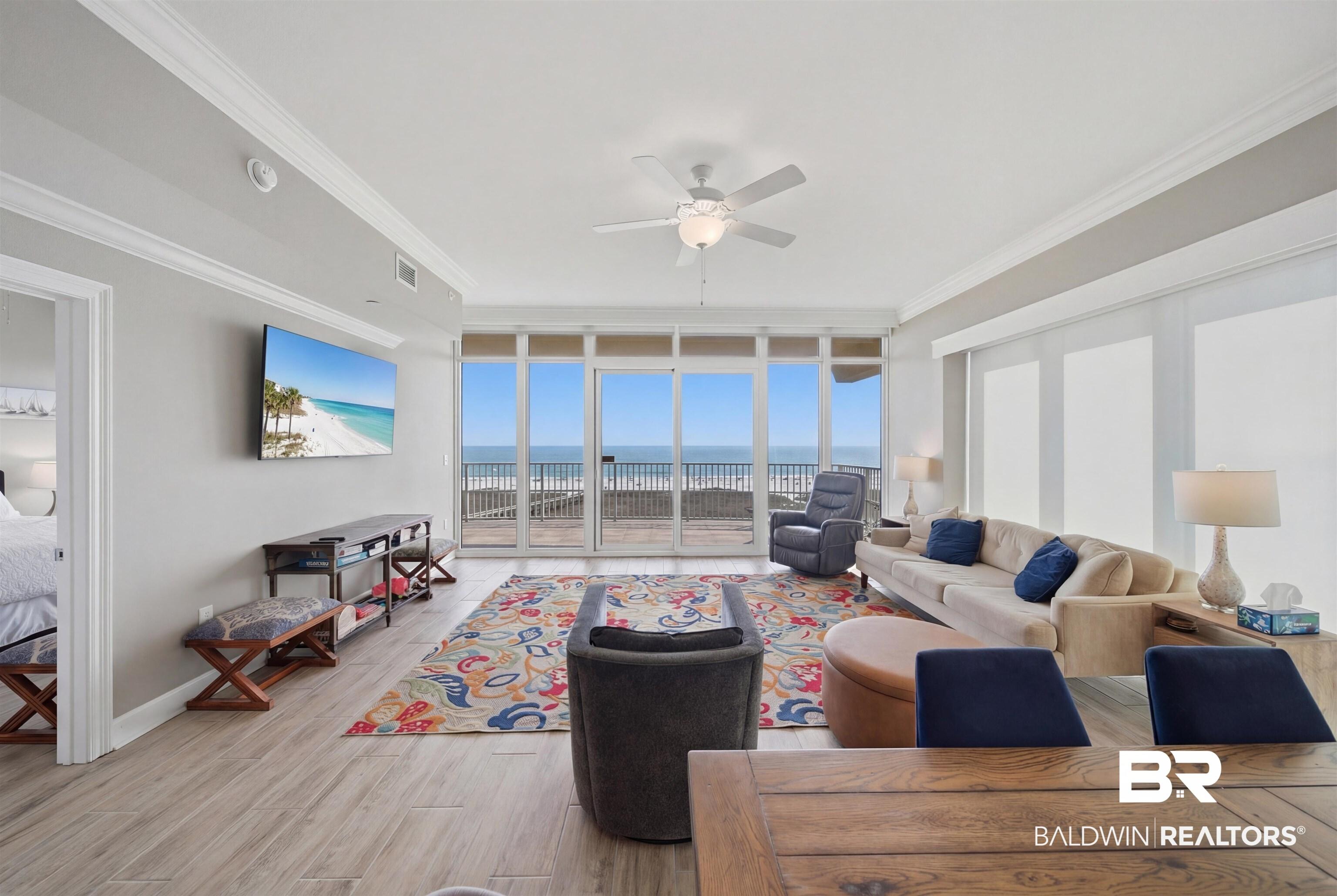 Image 2: Living area featuring floor to ceiling windows, light wood-style floors, a ceiling fan, and ornamental molding