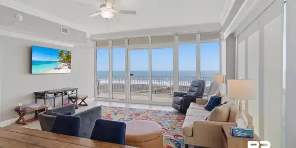 Image 3: Living room featuring expansive windows, crown molding, ceiling fan, and wood finished floors