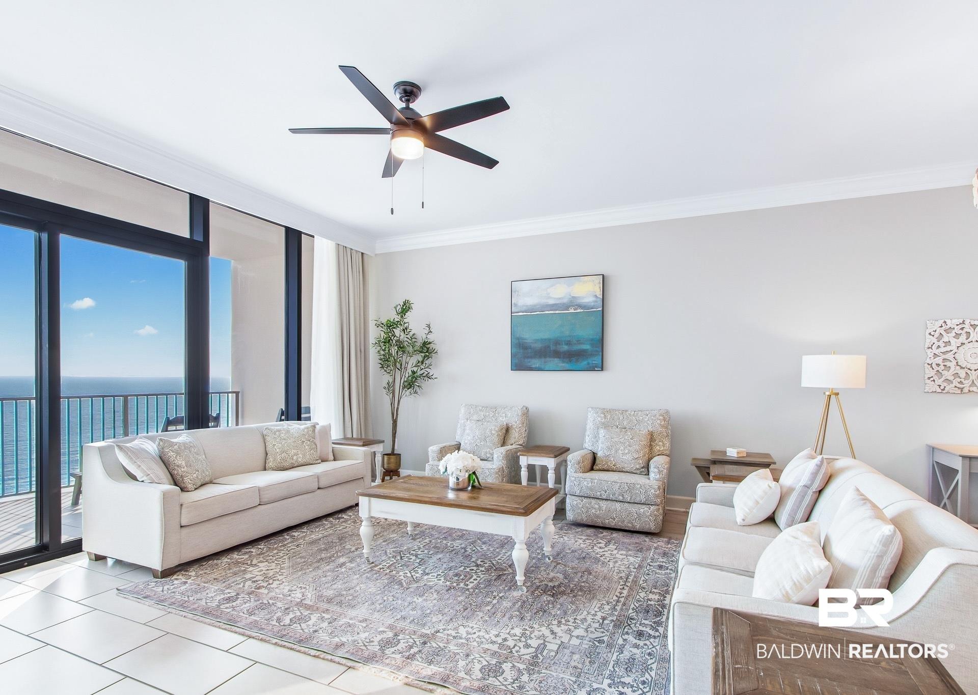 Image 2: Expansive living area featuring large format tile flooring and crown molding