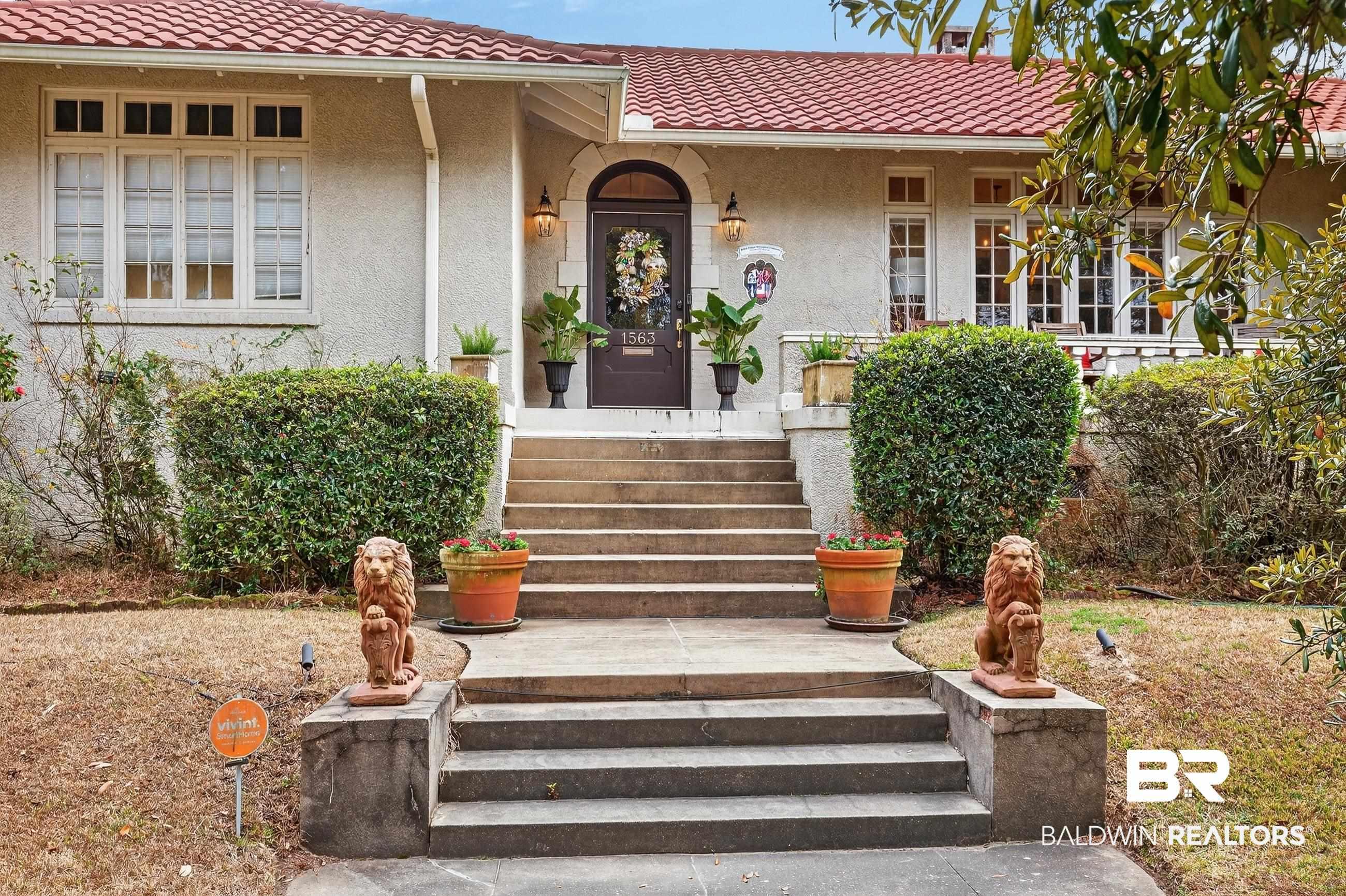 Image 2: Doorway to property with a tiled roof, stucco siding, and covered porch