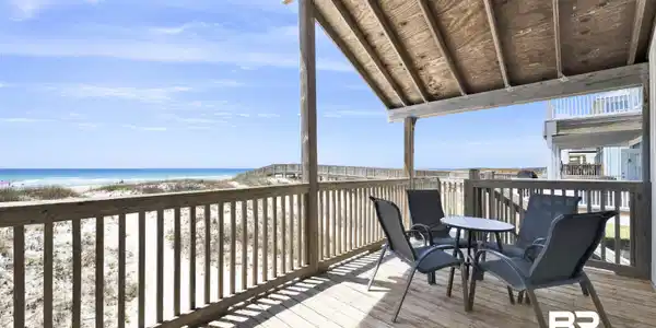 Image 2: Expansive outdoor deck featuring wood flooring and a slatted wood railing