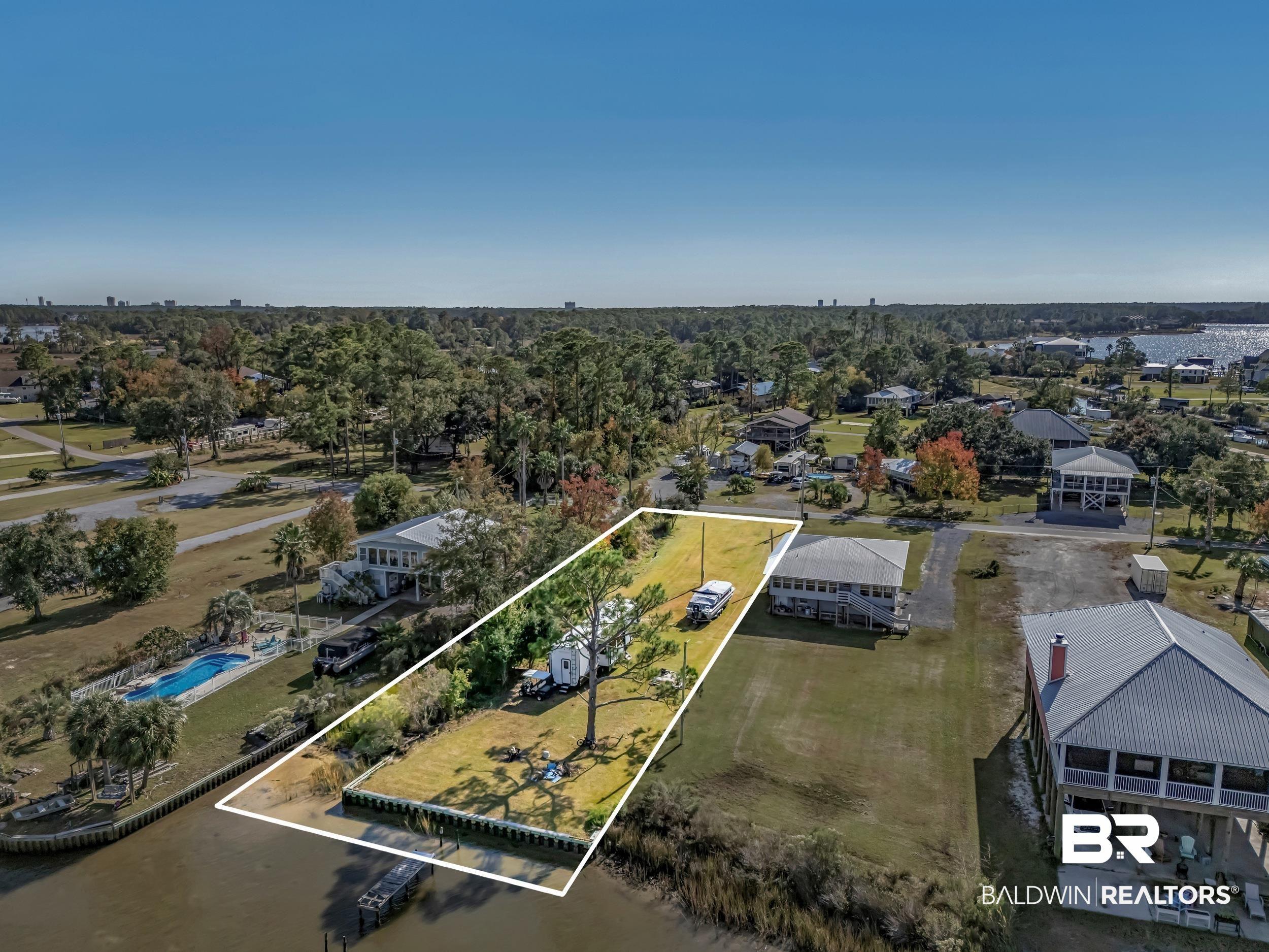 Image 2: Aerial overview of property's location featuring property parcel outlined and a large body of water