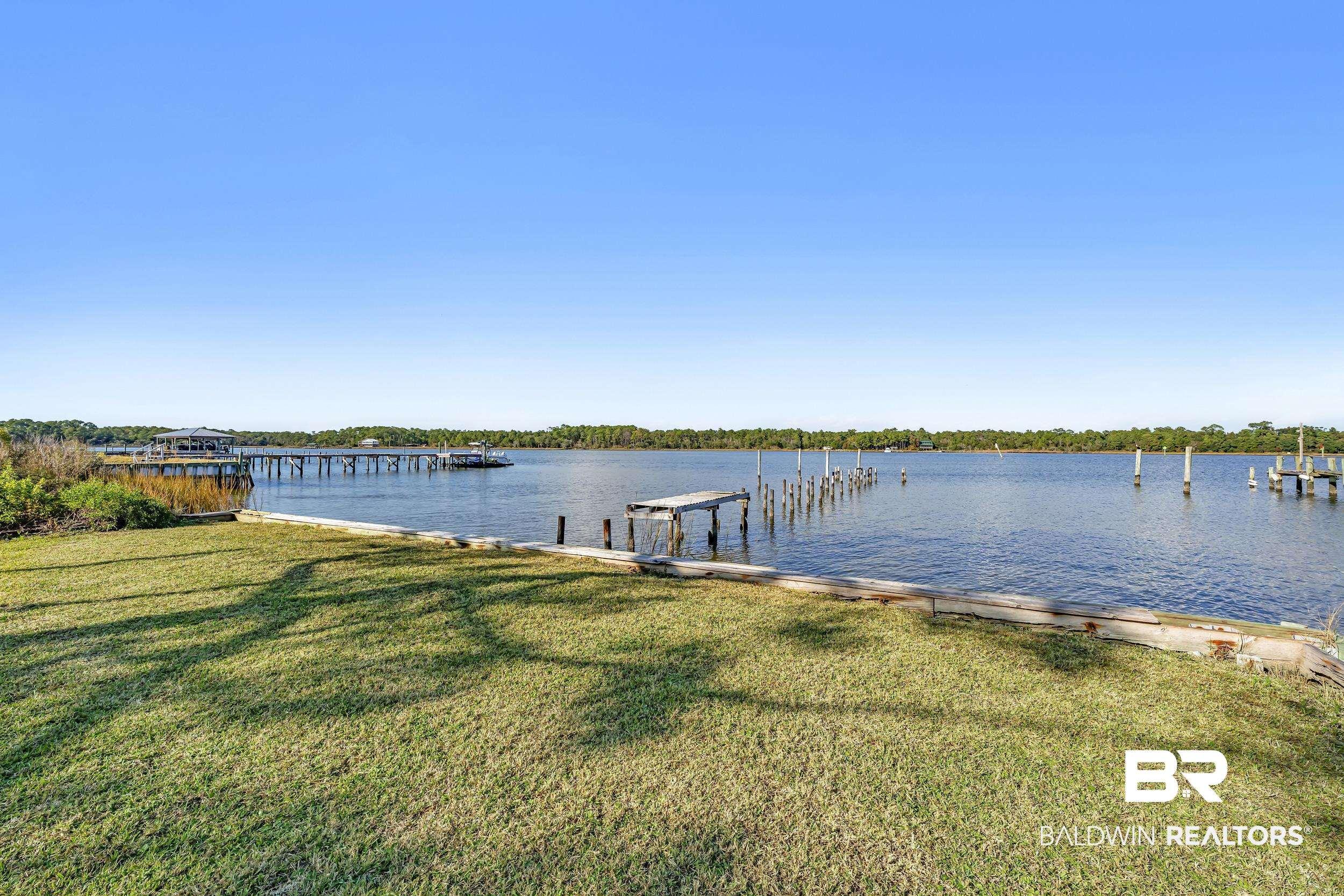 Image 3: Dock area featuring a yard and a water view