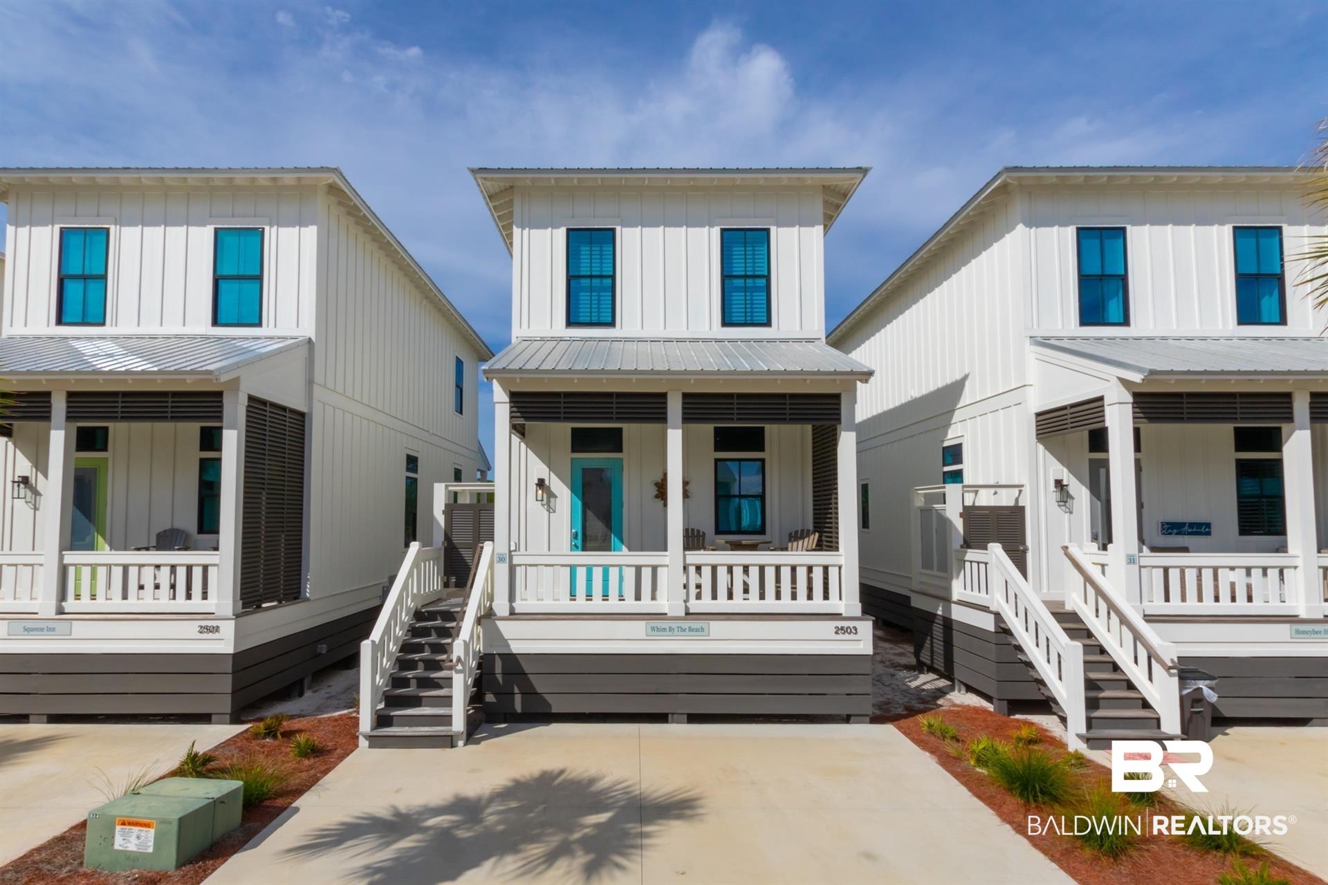 Image 2: View of front of property with a porch, board and batten siding, stairs, and metal roof