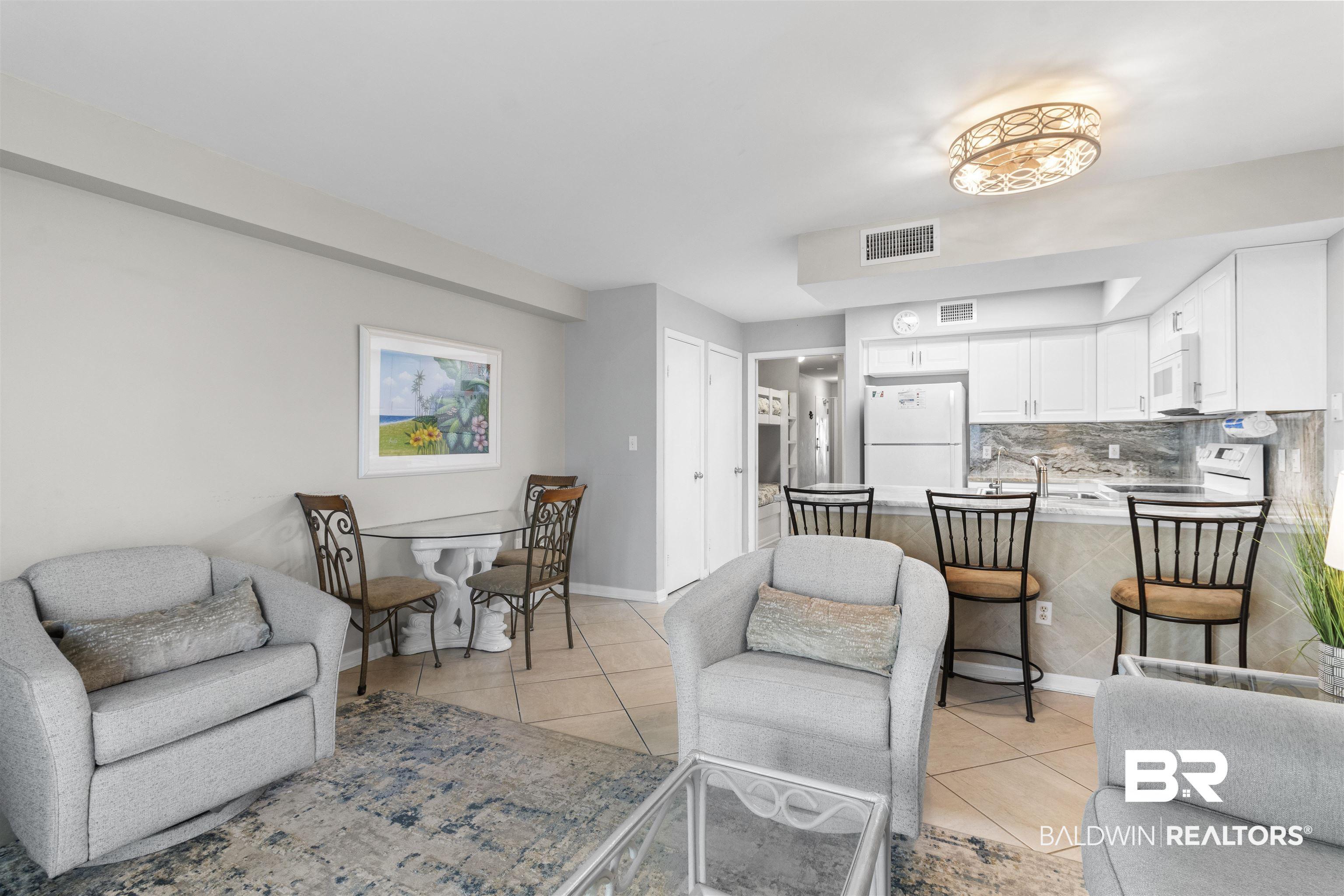 Image 3: Living room featuring light tile patterned flooring and baseboards