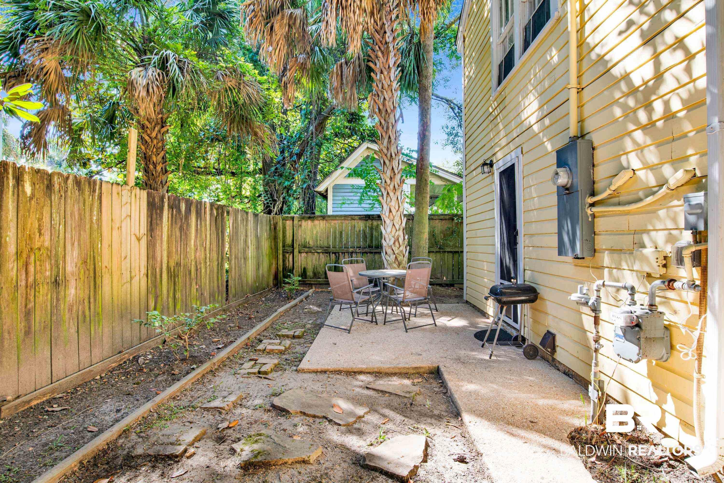 Image 4: View of patio featuring a fenced backyard, area for grilling, and outdoor dining space