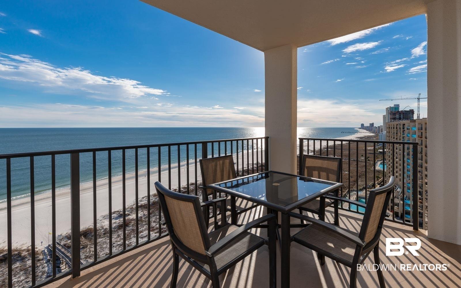 Image 3: Spacious balcony featuring direct oceanfront exposure, a white sand beach, and a black metal railing