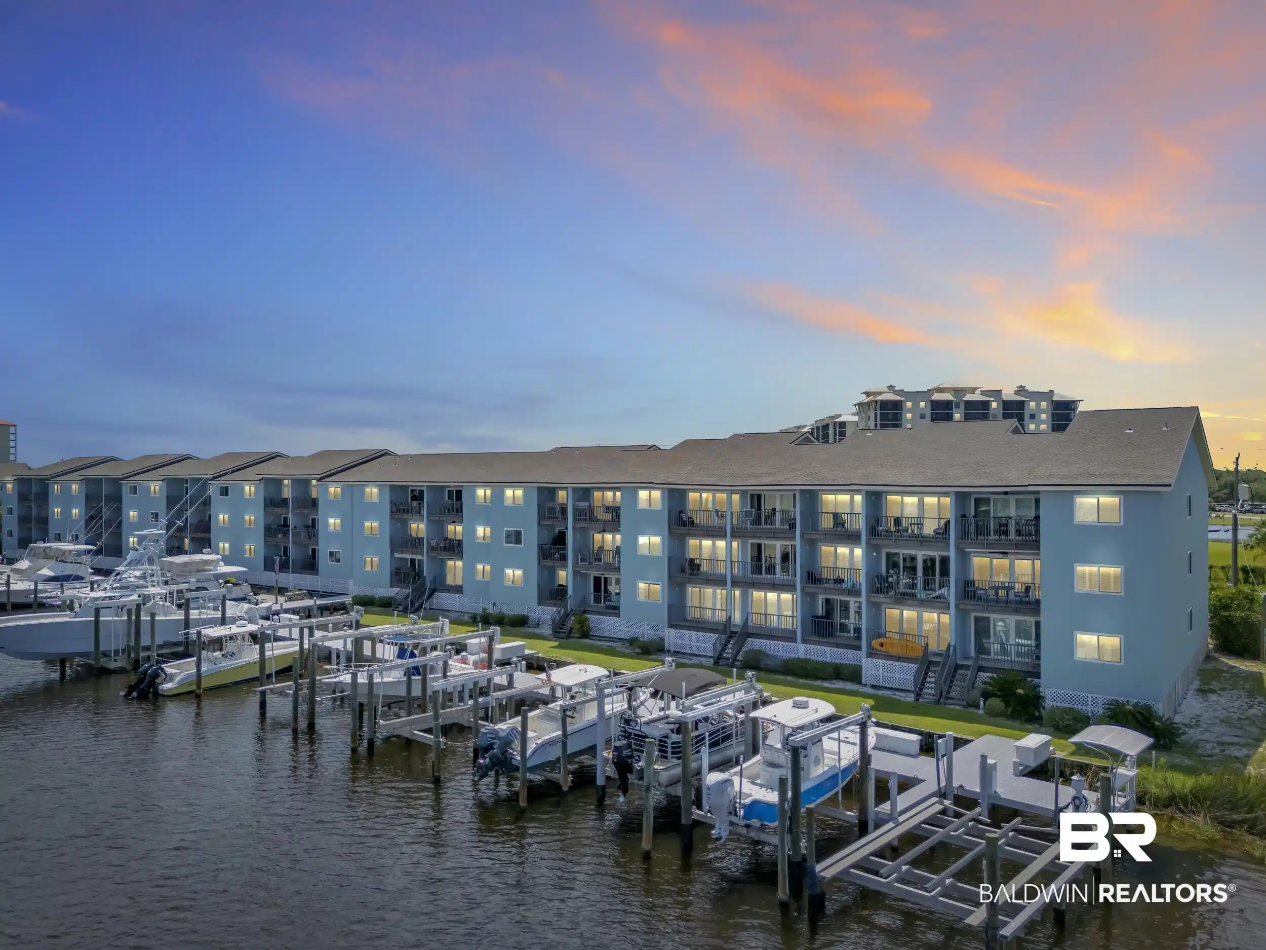Image 1: Waterfront multi-story building featuring private boat slips, individual balconies, and a coastal blue exterior
