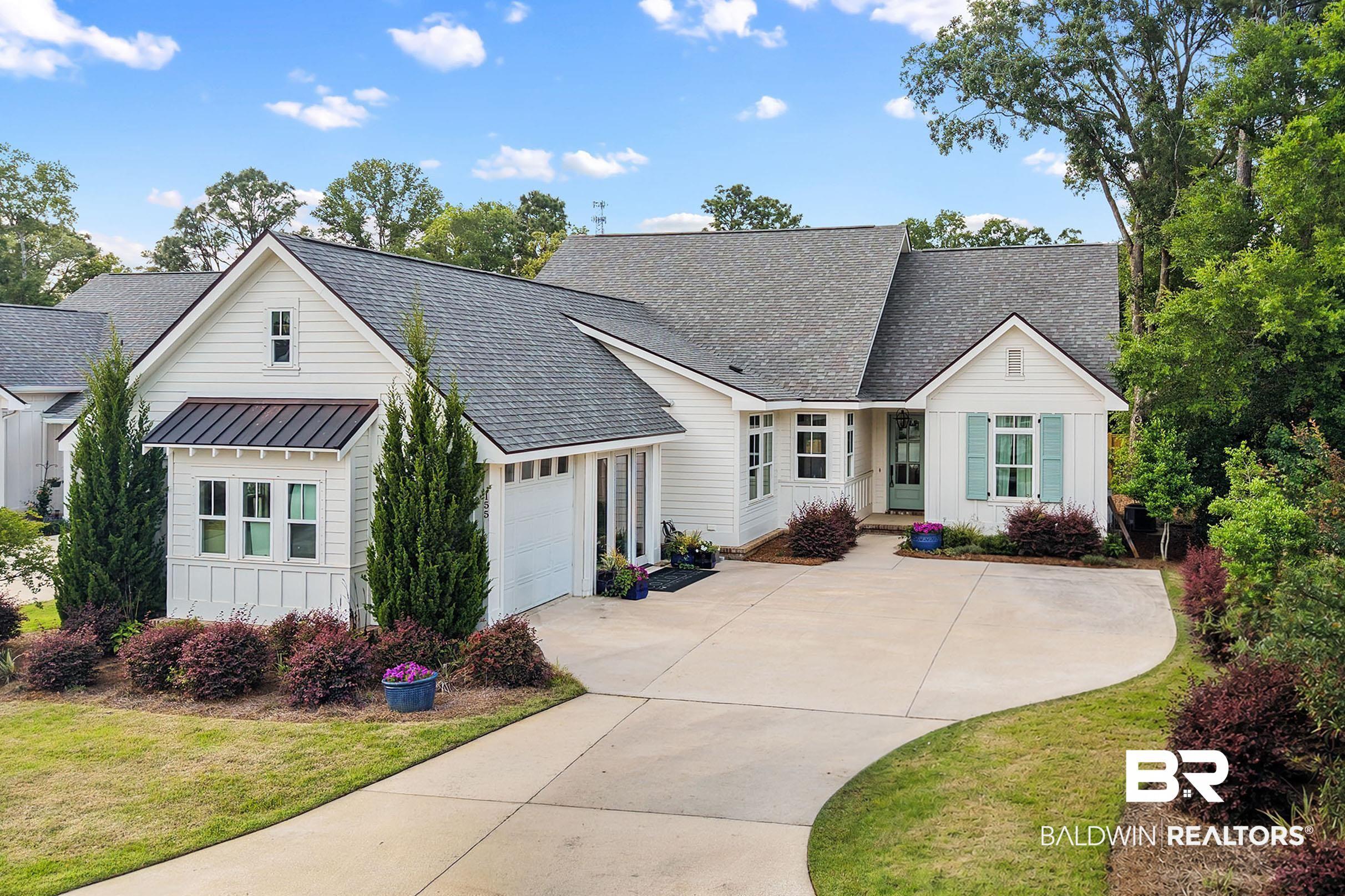 Image 2: White siding exterior with a dark shingle roof and contrasting teal shutters