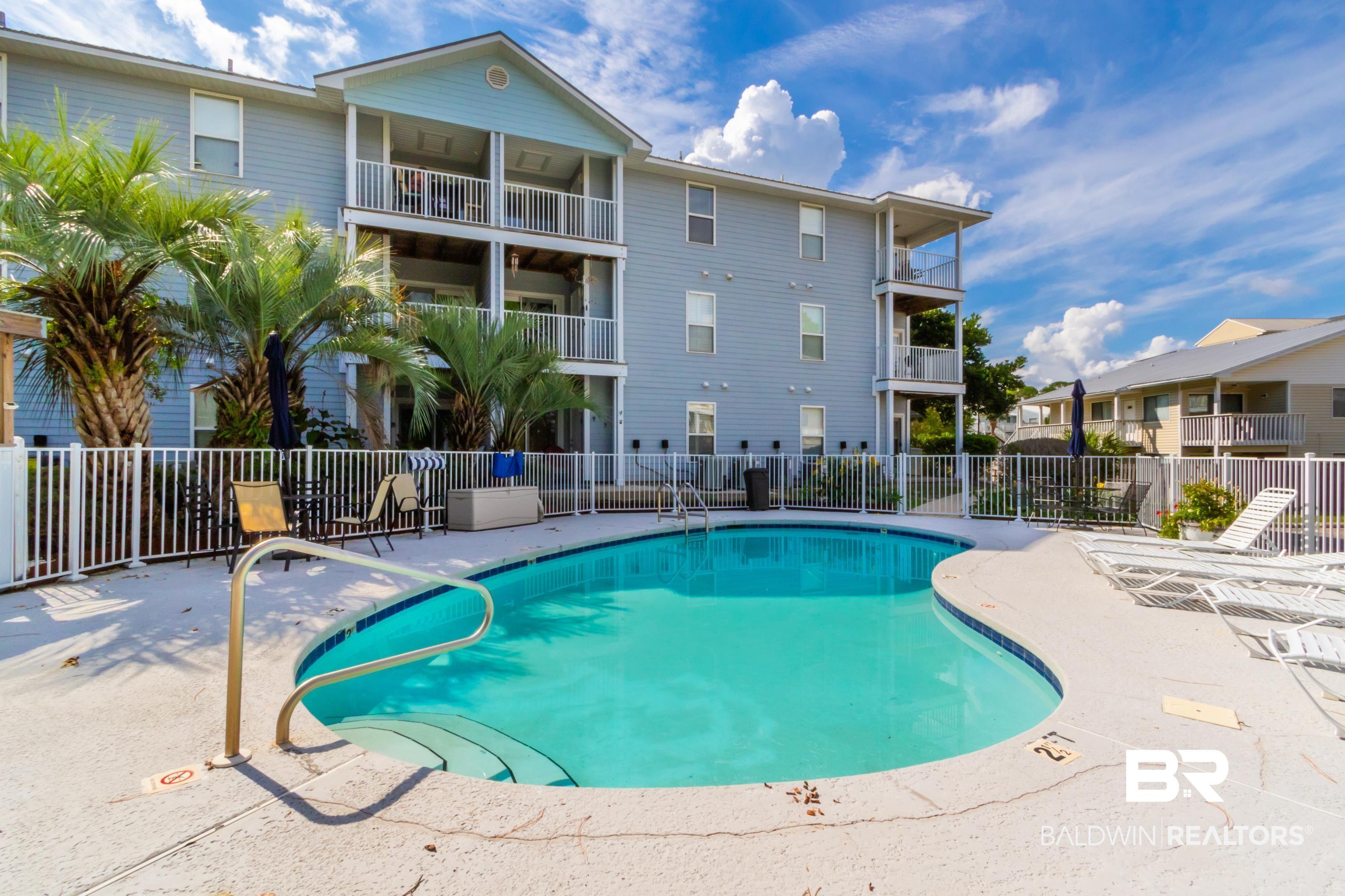 Image 1: Resort-style pool with integrated steps, surrounded by a white picket fence