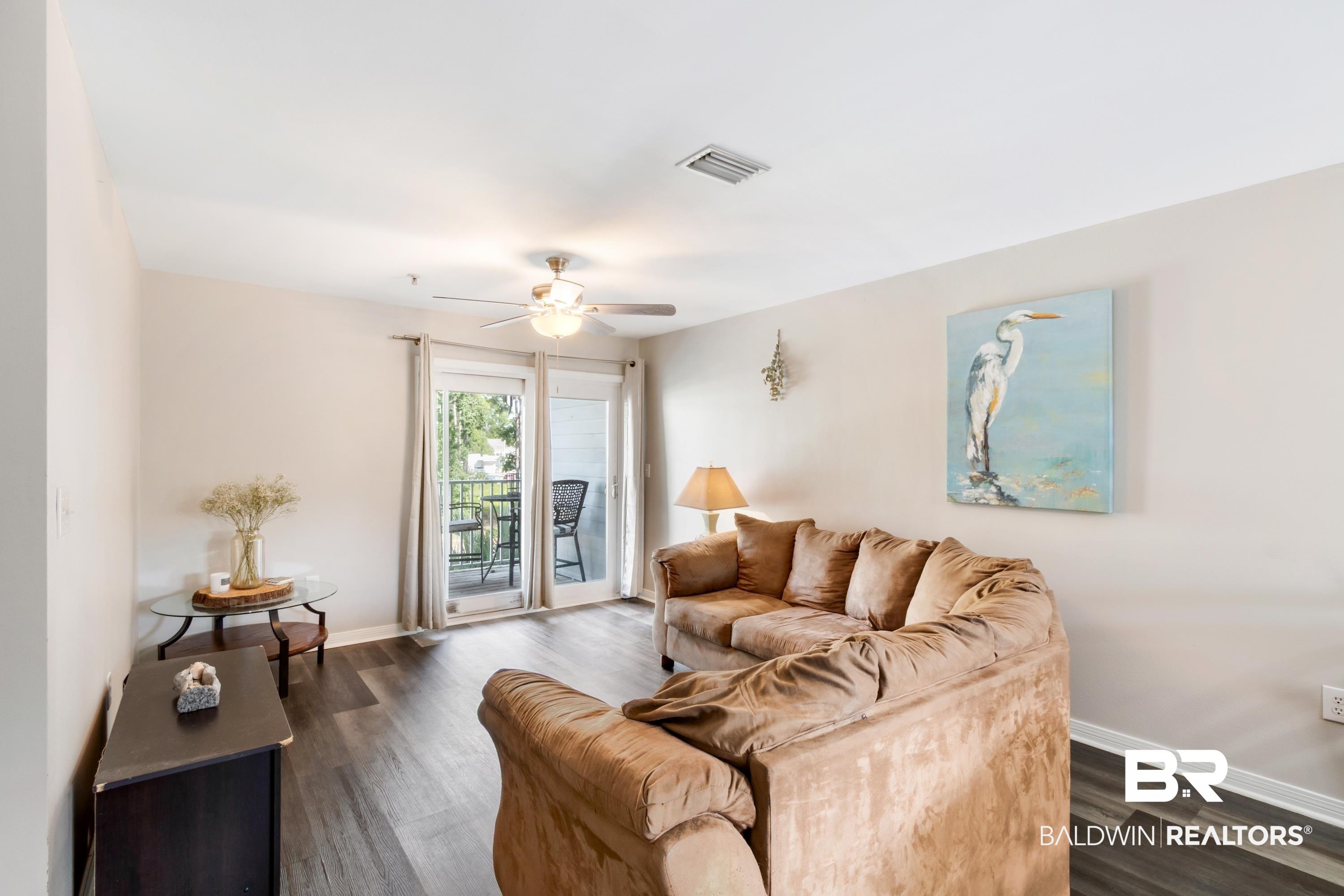 Image 3: Living area featuring wood-finish flooring, light neutral wall paint, and a ceiling fan with integrated lighting
