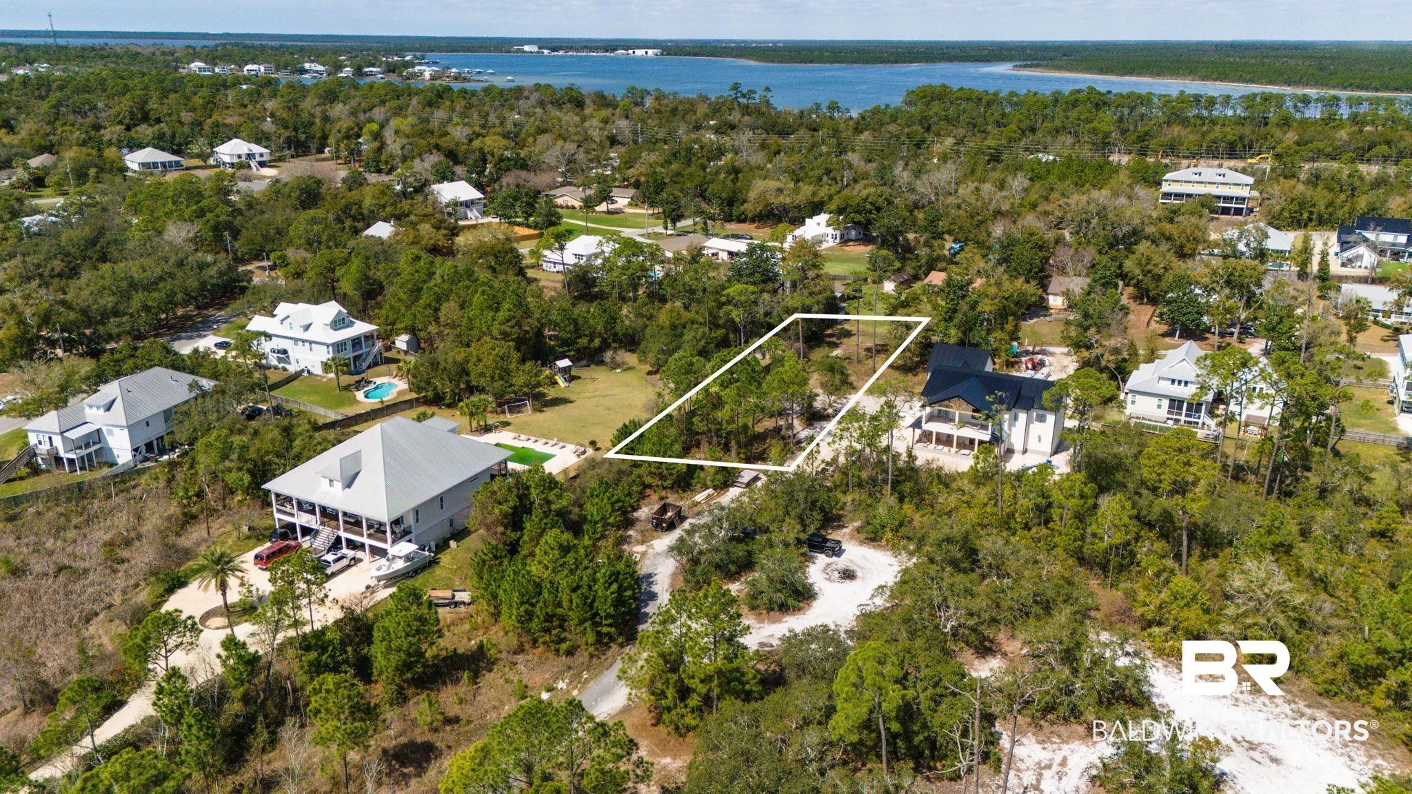 Image 3: Aerial perspective of suburban area with a nearby body of water and property boundaries highlighted