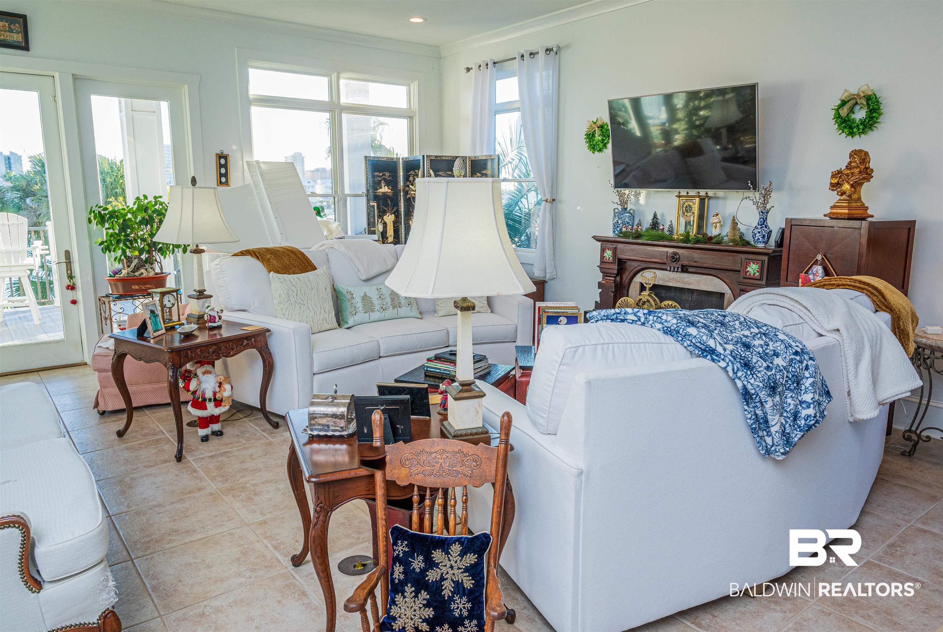 Image 2: Living area with crown molding and light tile patterned flooring