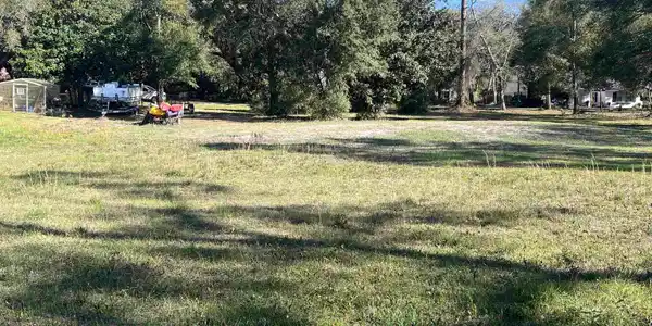 Image 2: View of green lawn featuring view of wooded area