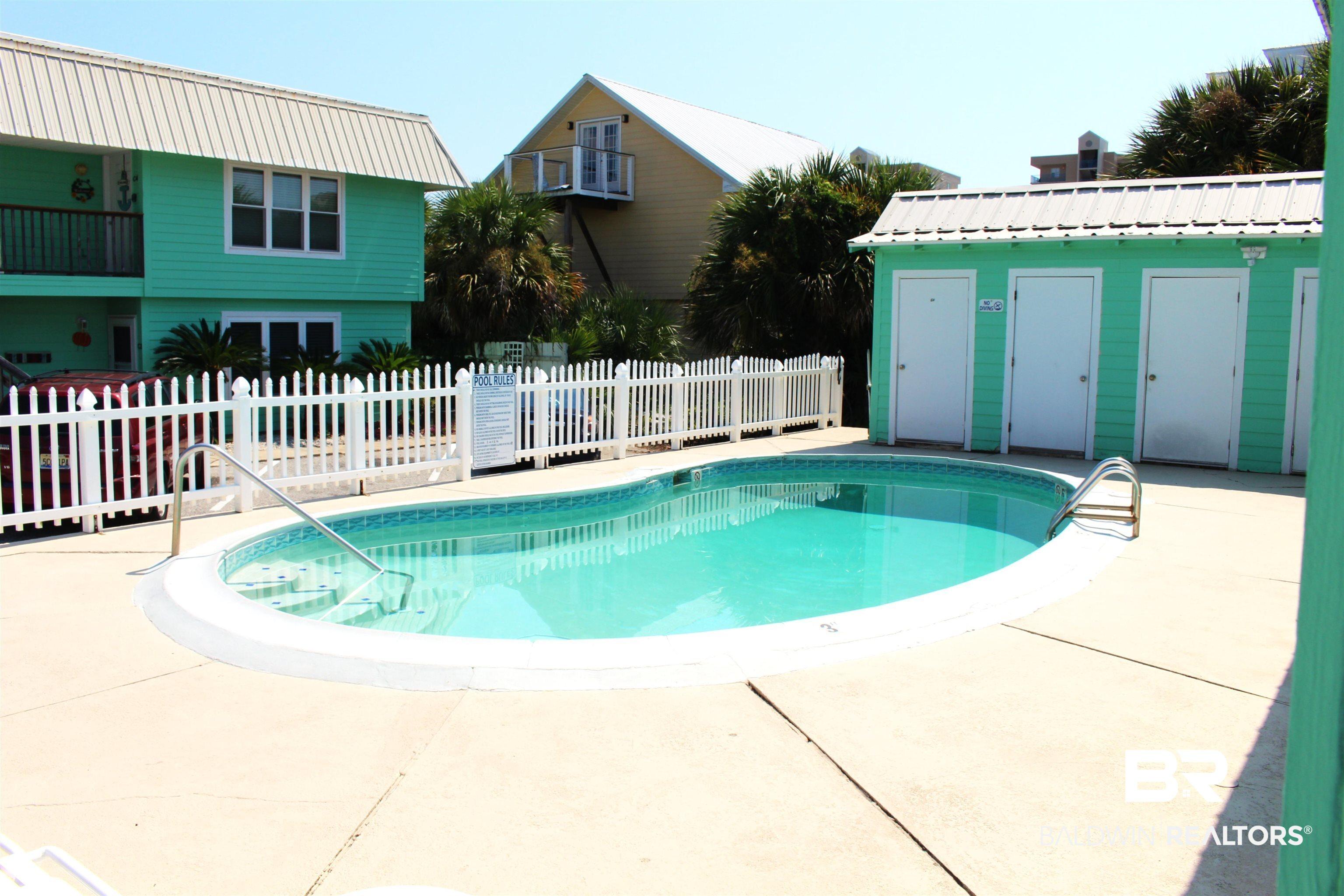 Image 4: View of pool with patio surround and an outbuilding