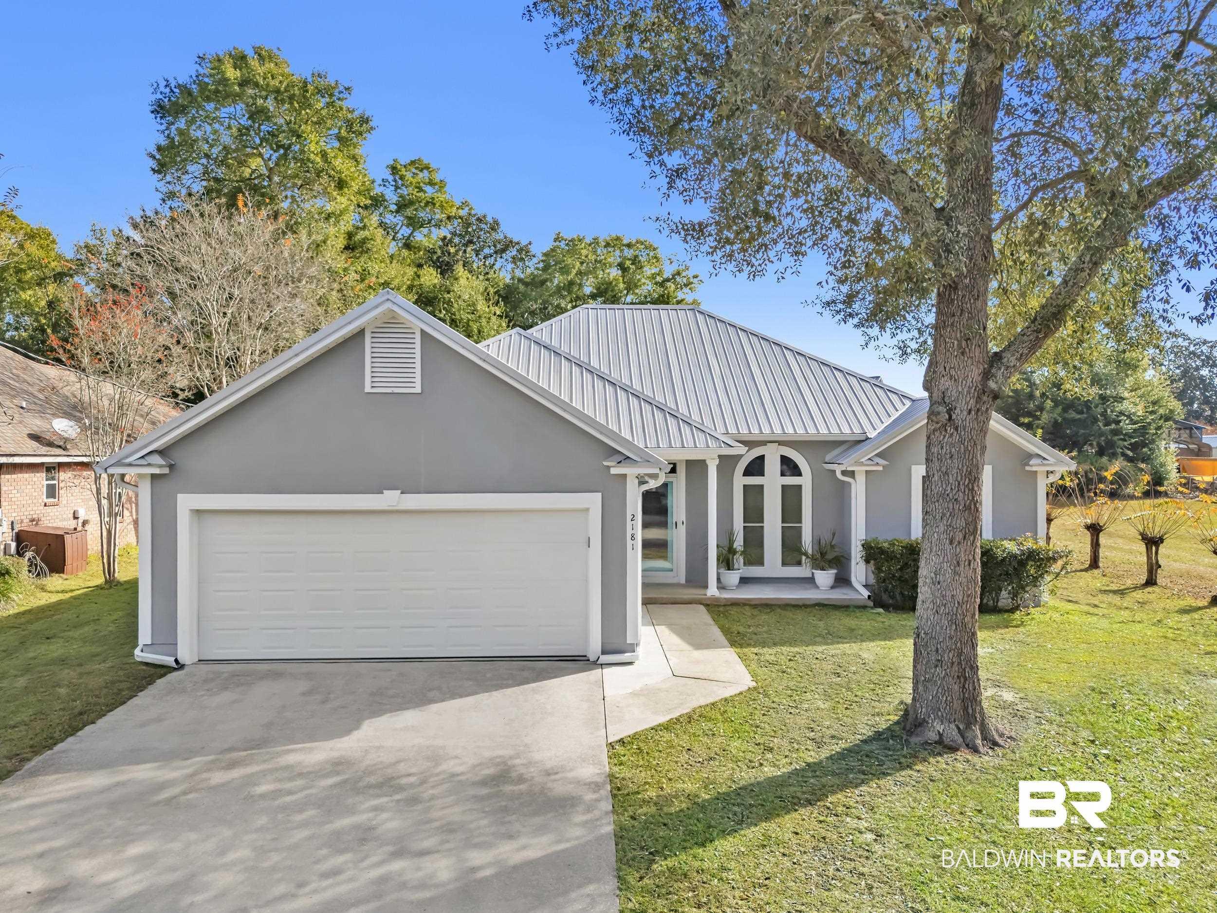 Image 1: Ranch-style house featuring a front yard, stucco siding, driveway, and an attached garage