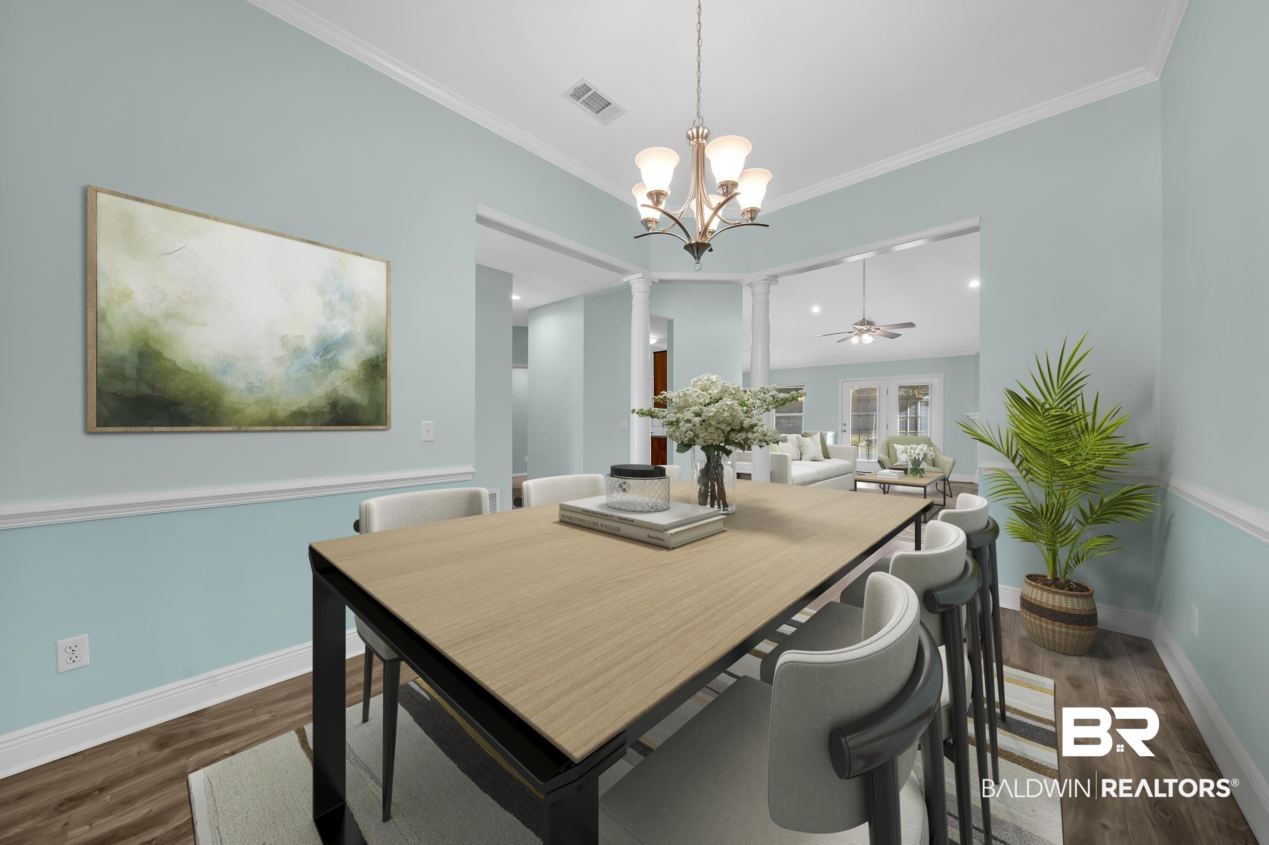 Image 3: Dining area with a ceiling fan, dark wood finished floors, ornamental molding, a chandelier, and ornate columns