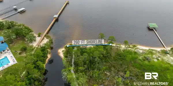 Image 3: Expansive waterfront parcel featuring 260 feet of shoreline, natural sandy beach access, and mature trees