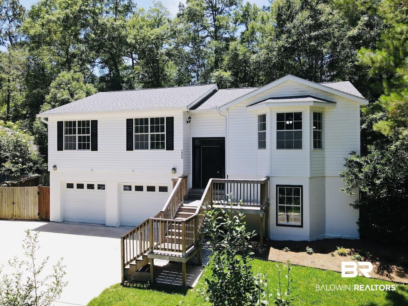 Image 1: Two-story residence featuring white siding and a gray shingle roof