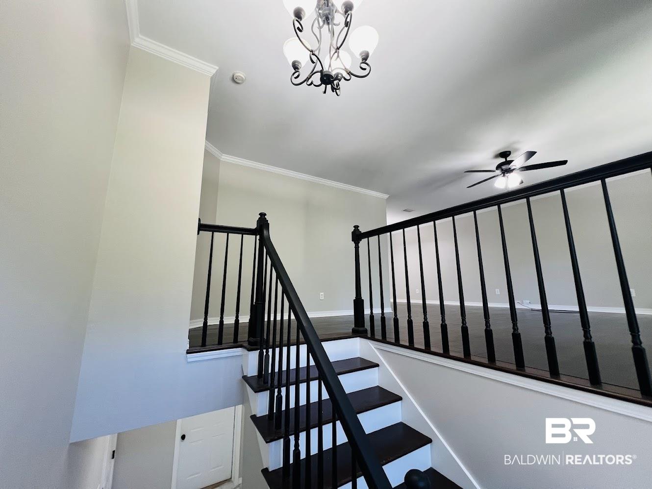 Image 3: Staircase with dark wood-finish treads and white risers, featuring a black spindle railing