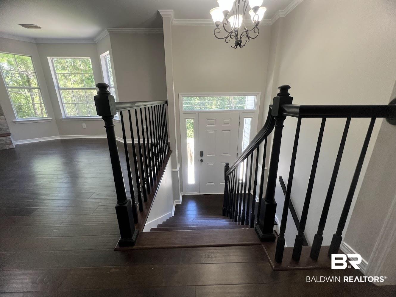 Image 4: Entryway staircase featuring dark wood-finish treads and risers with black balusters and handrails
