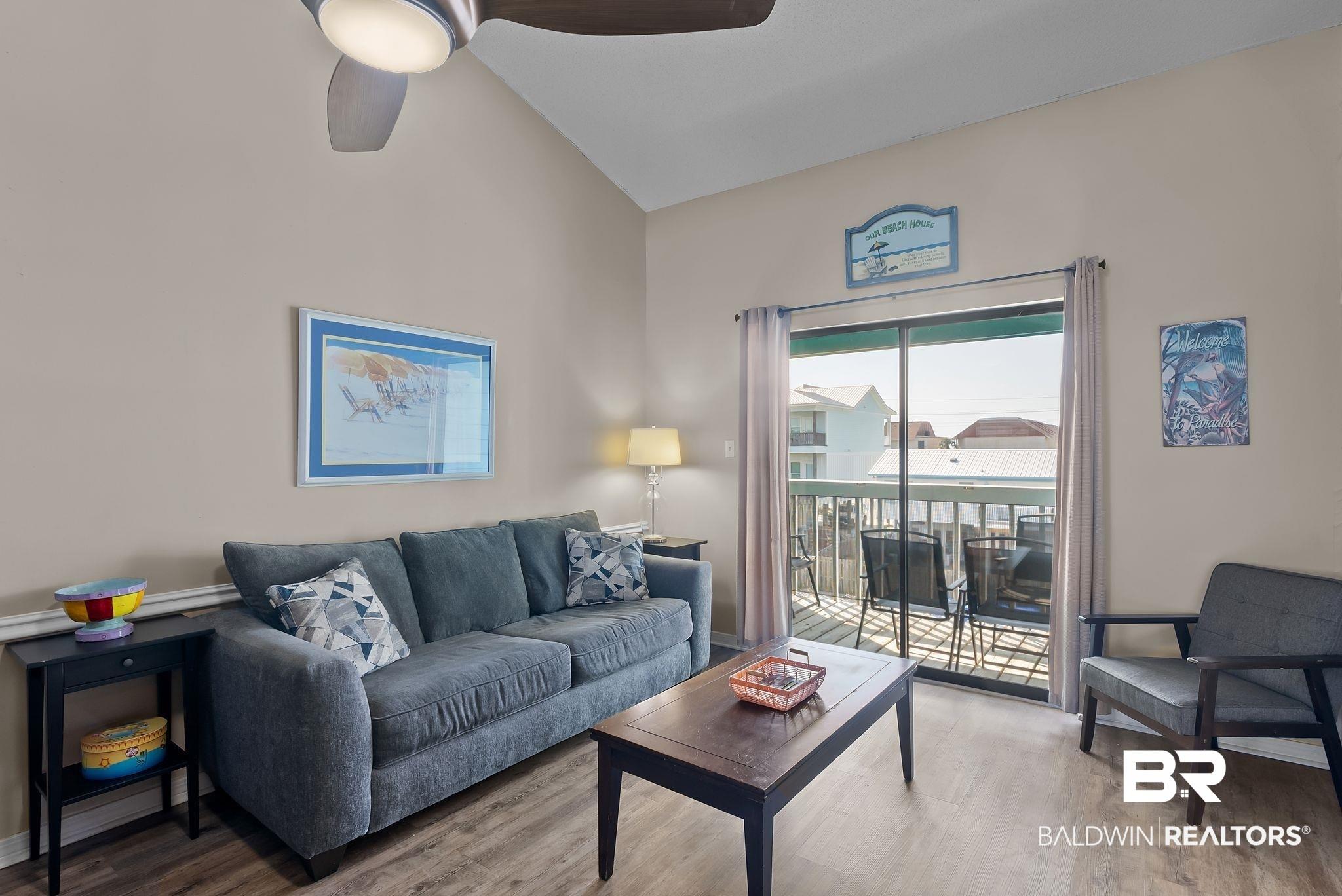 Image 3: Living room with vaulted ceiling, wood finished floors, and ceiling fan