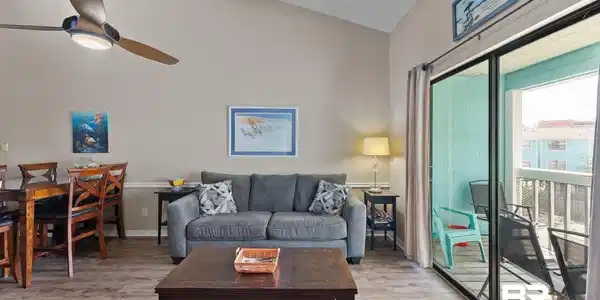 Image 4: Living area featuring vaulted ceiling with beams, wood finished floors, and ceiling fan