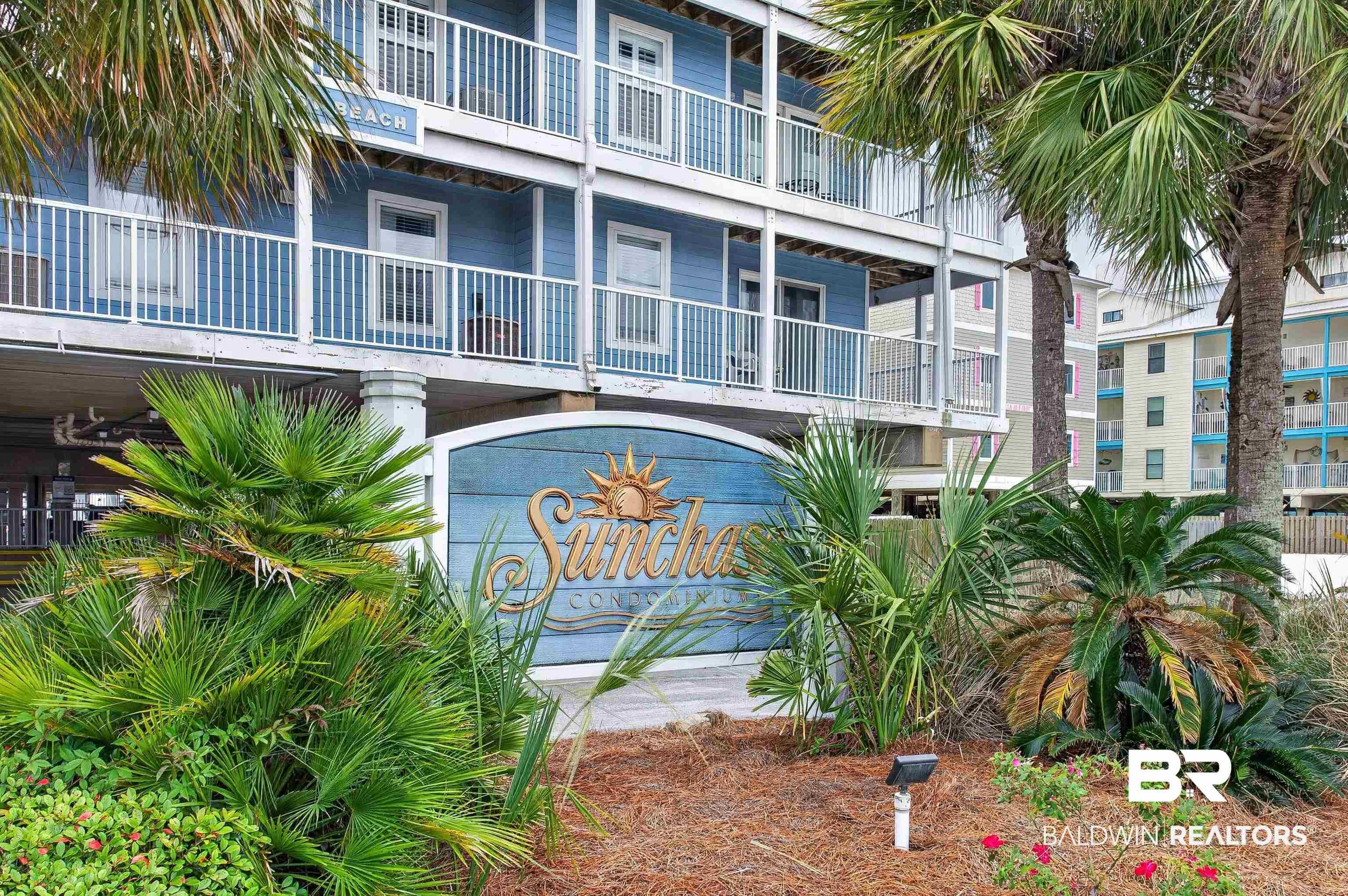 Image 2: Coastal architecture featuring multi-story balconies with white railings, a blue facade, and tropical landscaping