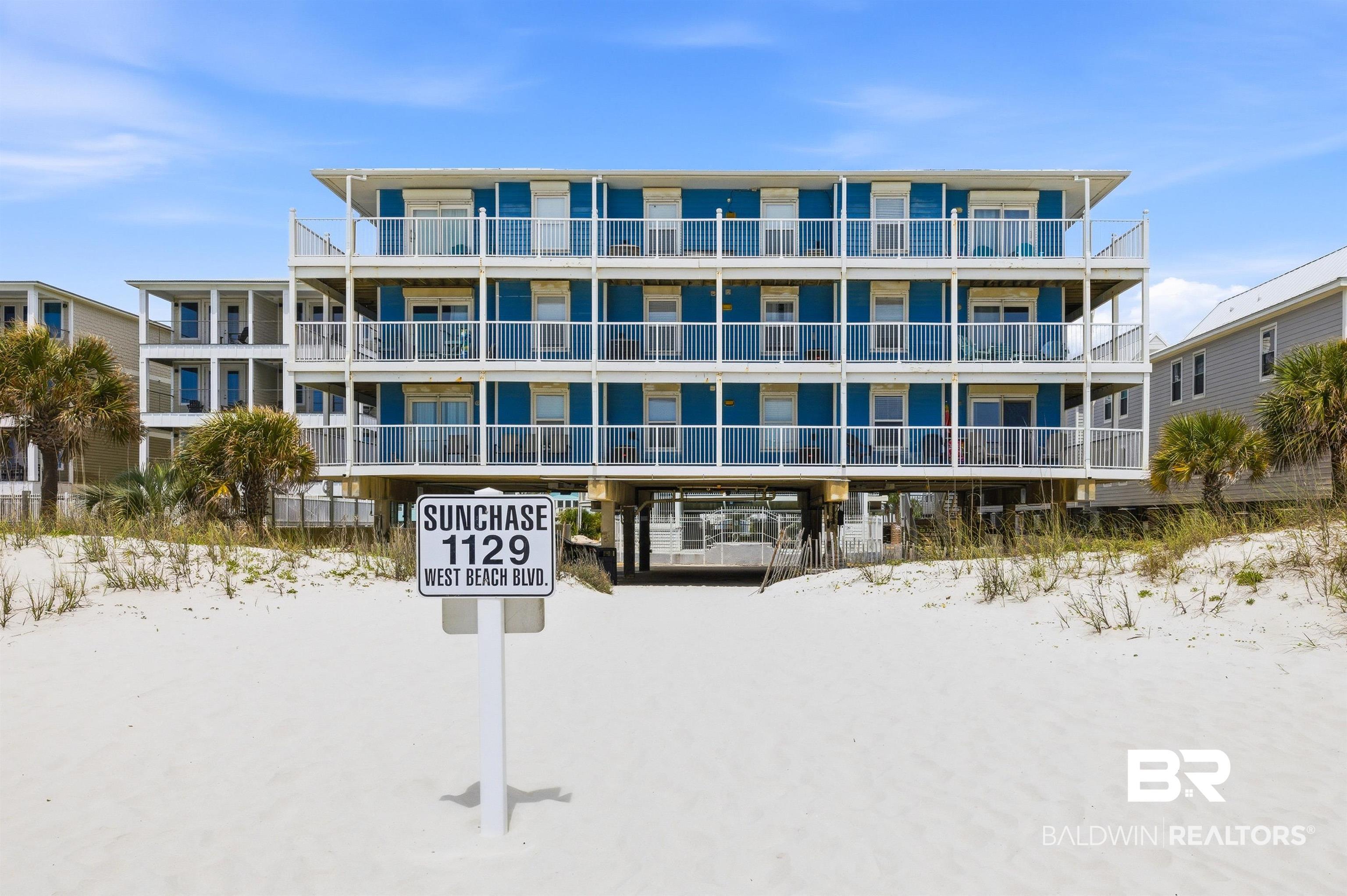 Image 3: Multi-story residential building with blue siding and multiple balconies