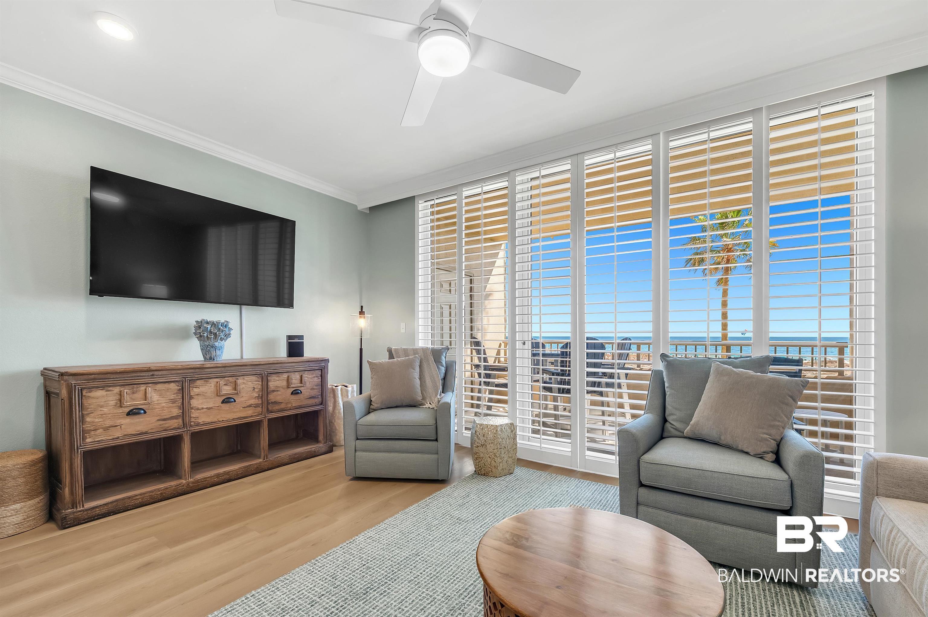 Image 4: Floor-to-ceiling windows with plantation shutters reveal a scenic outdoor environment