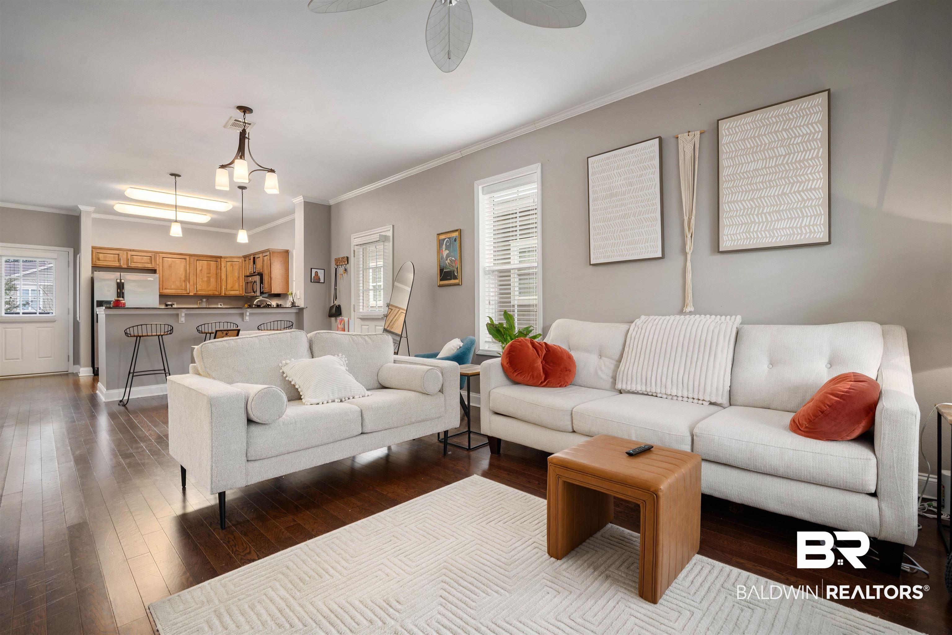 Image 2: Living room with ornamental molding, dark wood-style flooring, and ceiling fan