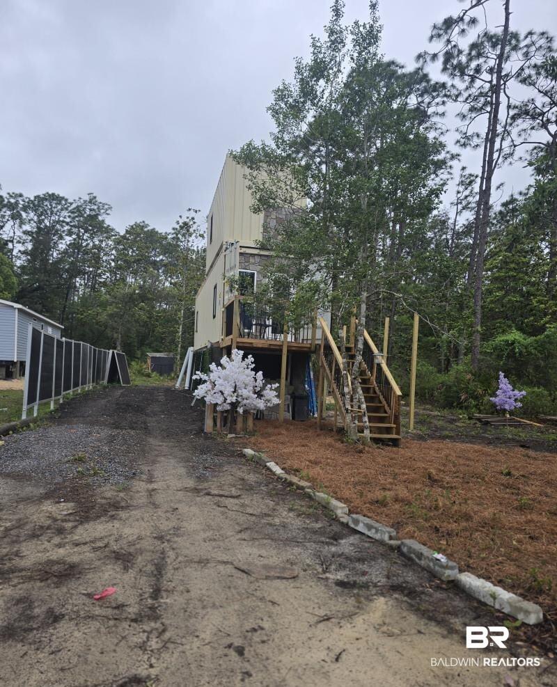 Image 1: Multi-level structure with tan siding and a dark lower level