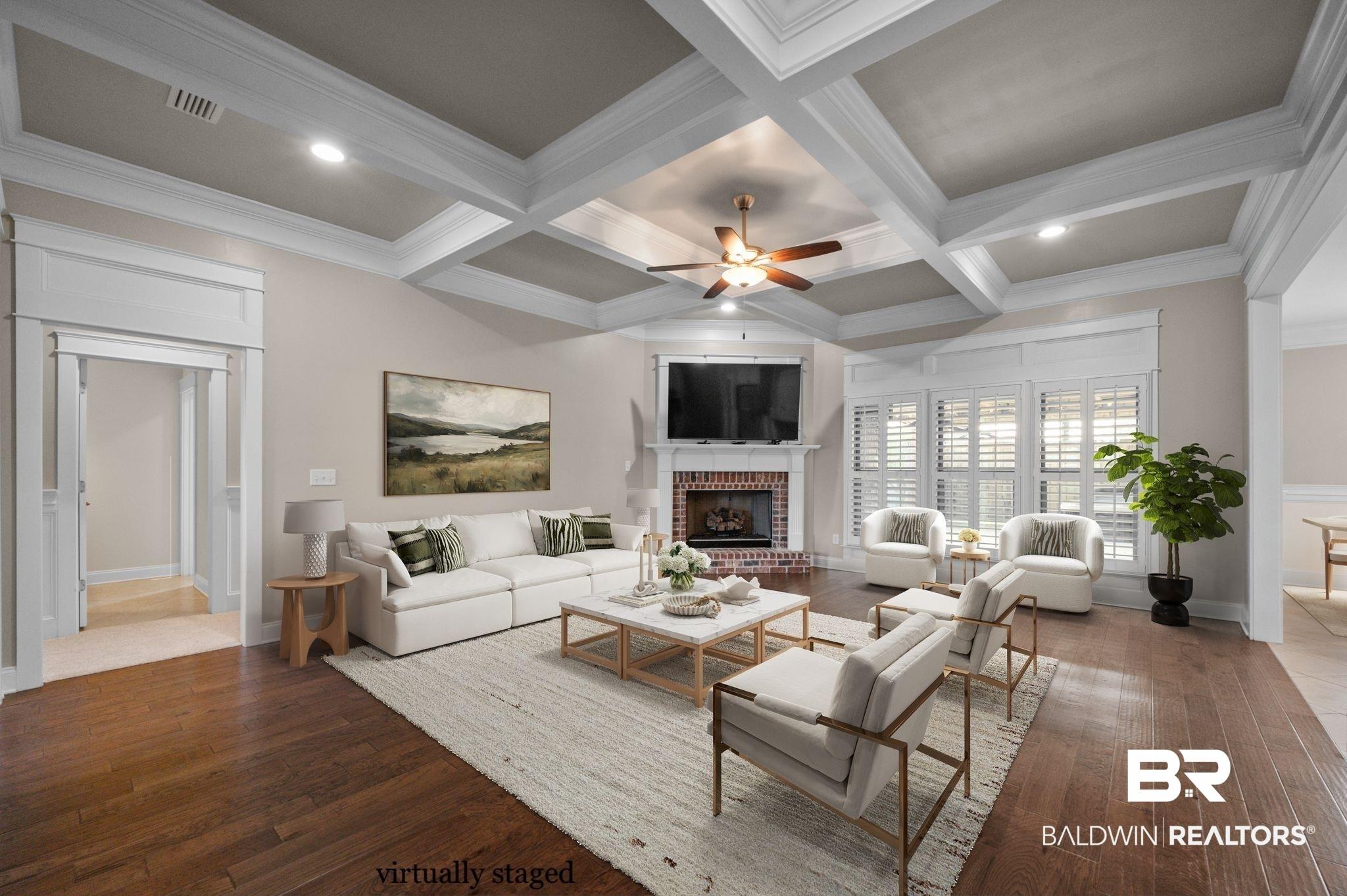 Image 2: Living area featuring a ceiling fan, coffered ceiling, wood-type flooring, a fireplace, and ornamental molding